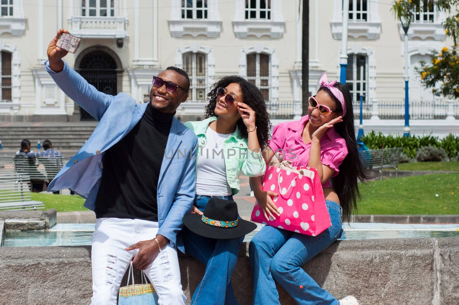 family of three people taking a selfie with a smartphone very smiling after shopping on black friday by Raulmartin