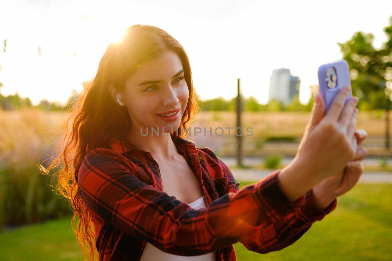 Portrait of a pretty girl taking a selfie at sunbeam.