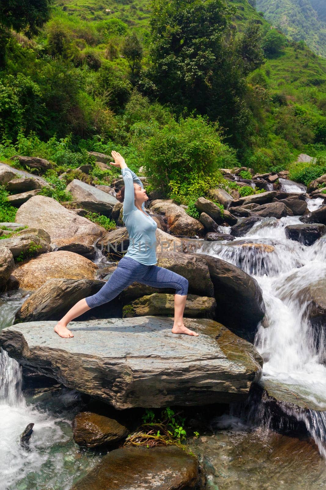 Woman doing Ashtanga Vinyasa Yoga asana Virabhadrasana 1 Warrior by dimol