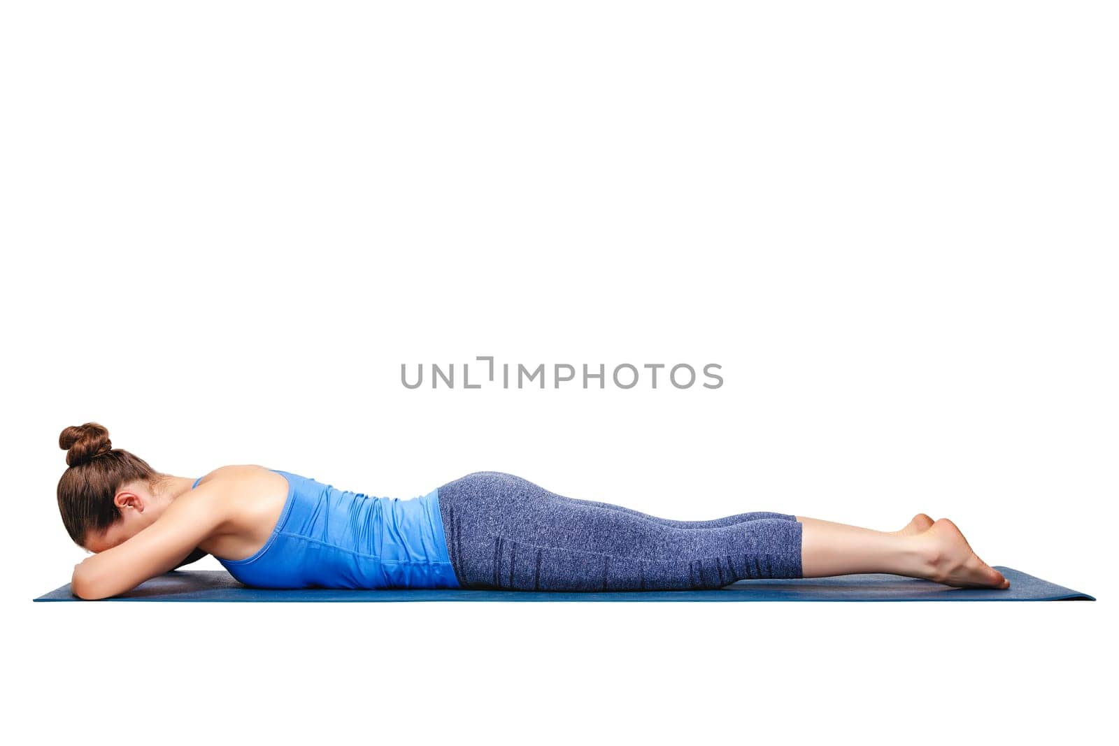 Woman relaxes in Hatha yoga asana Makarasana - crocodile pose isolated on white