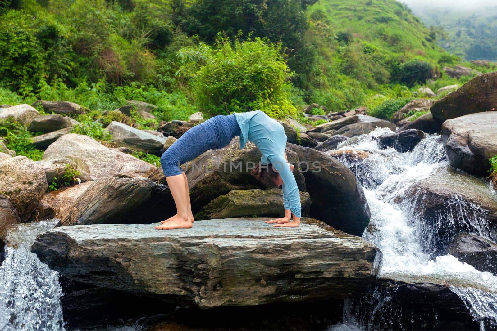 Woman doing Ashtanga Vinyasa Yoga asana Urdhva Dhanurasana - up by dimol