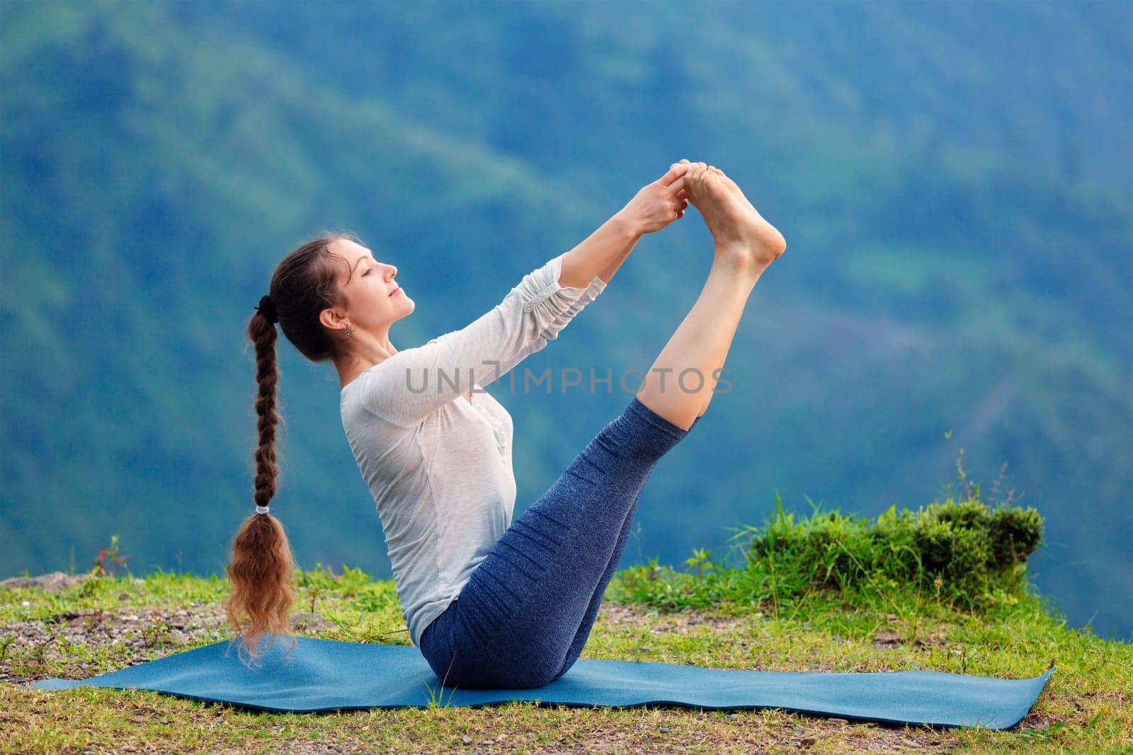 Woman doing Ashtanga Vinyasa Yoga asana outdoors by dimol