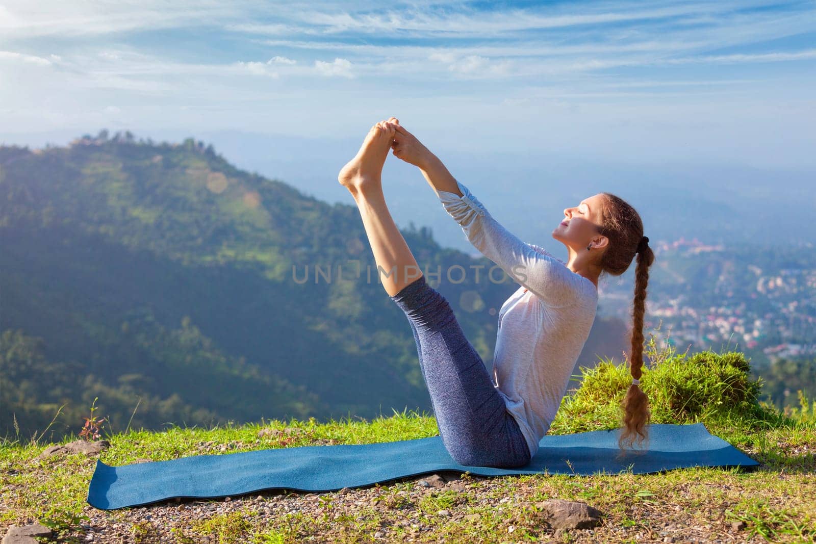 Woman doing Ashtanga Vinyasa Yoga asana outdoors by dimol