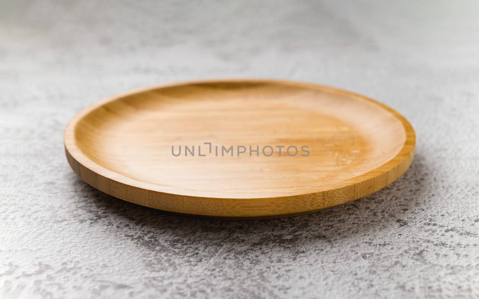 Wooden plate on a white stone background. handmade cooking utensils by Sonat