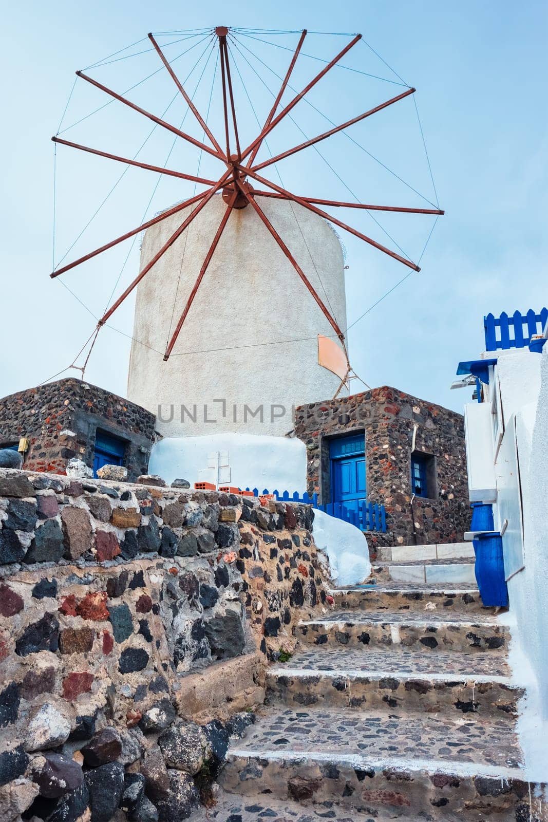 Old greek windmill on Santorini island in Oia town with stairs in street. Santorini, Greece by dimol