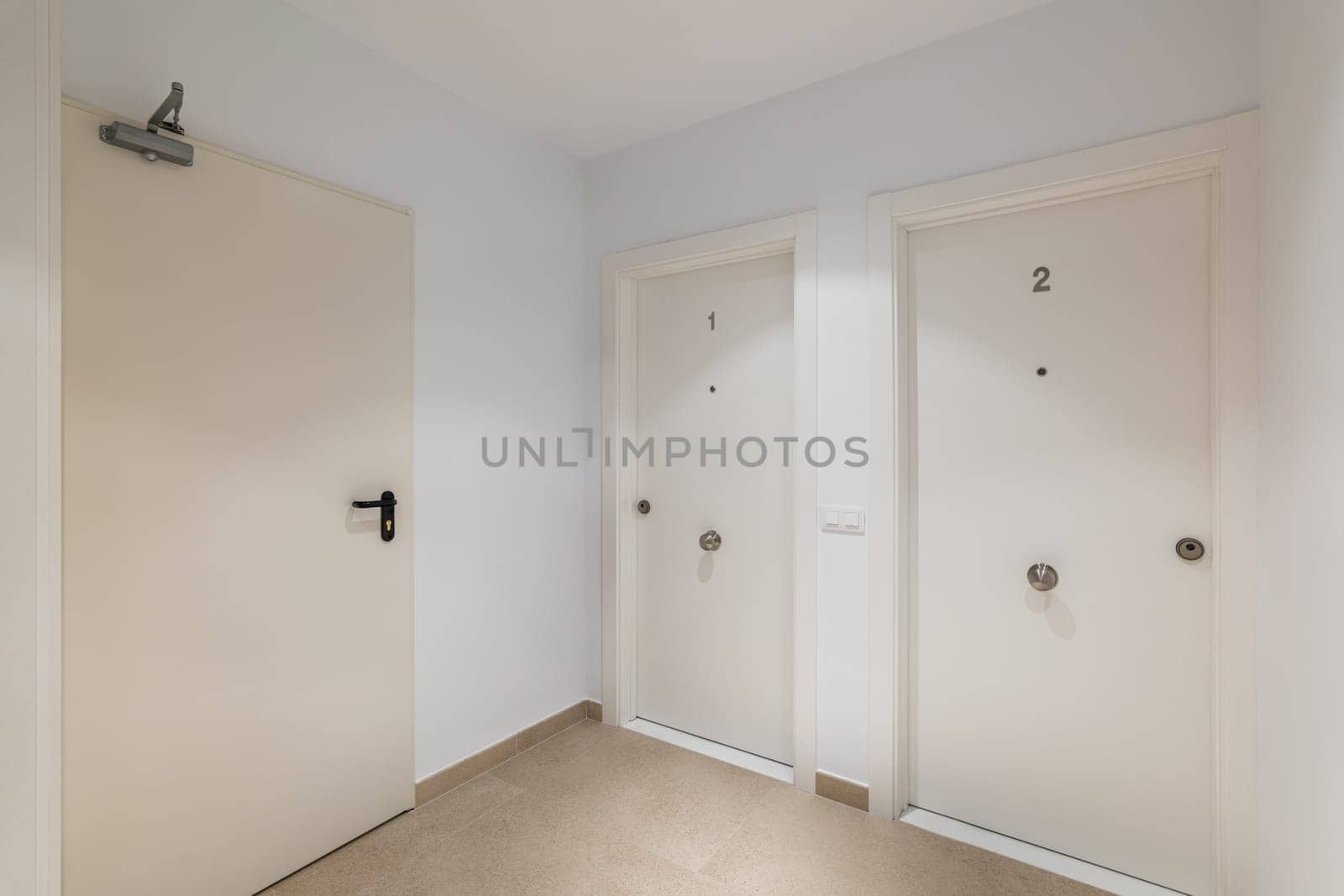 Hall space with two entrance doors to apartments or hotel rooms with the numbers one and two in white. The concept of a cozy compact five-star hotel by apavlin