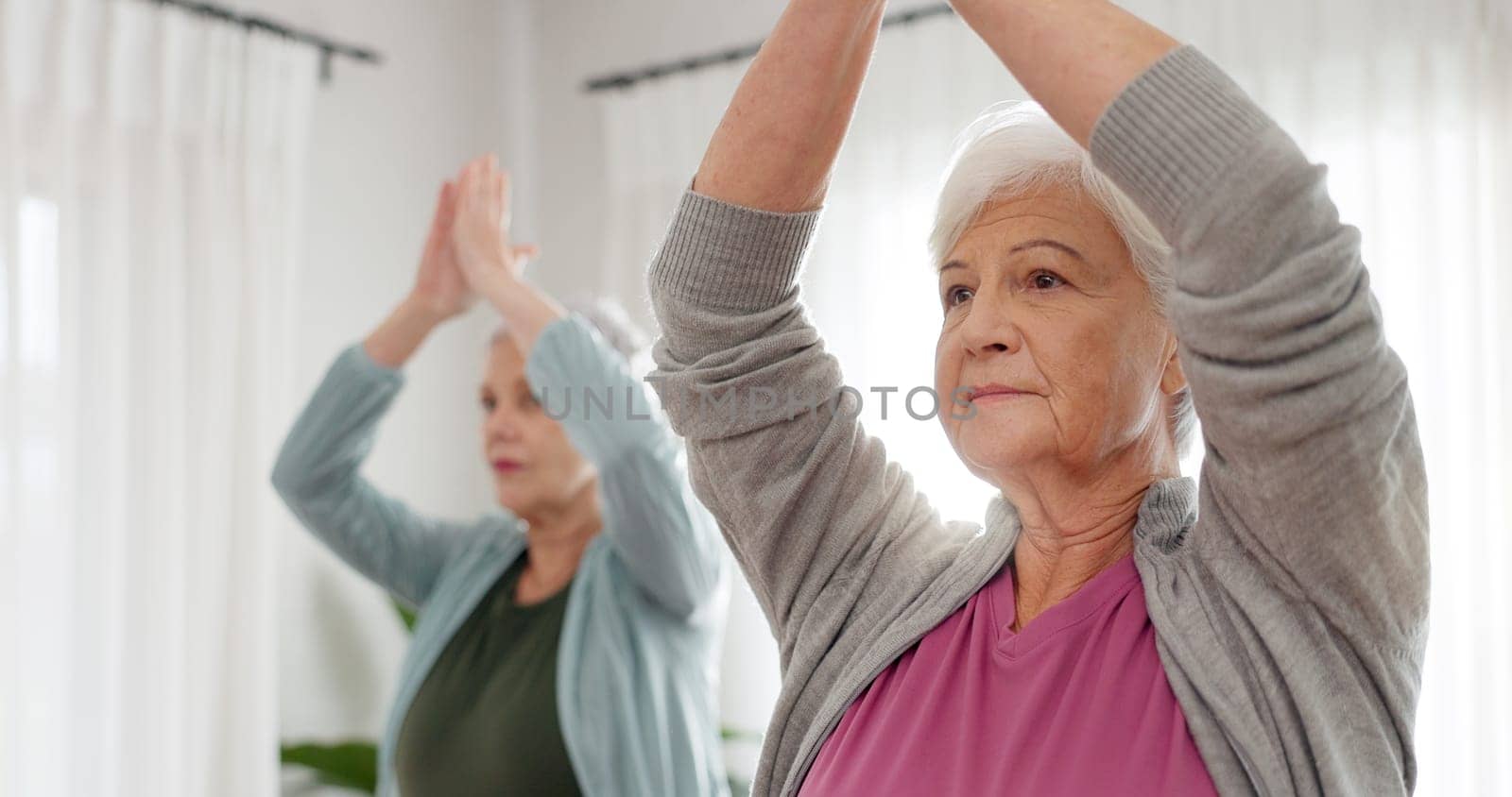 Senior women, yoga and class with friends and retirement home caregiver with a smile. Fitness, elderly group and workout for wellness and health with nurse in a living room with exercise to relax.