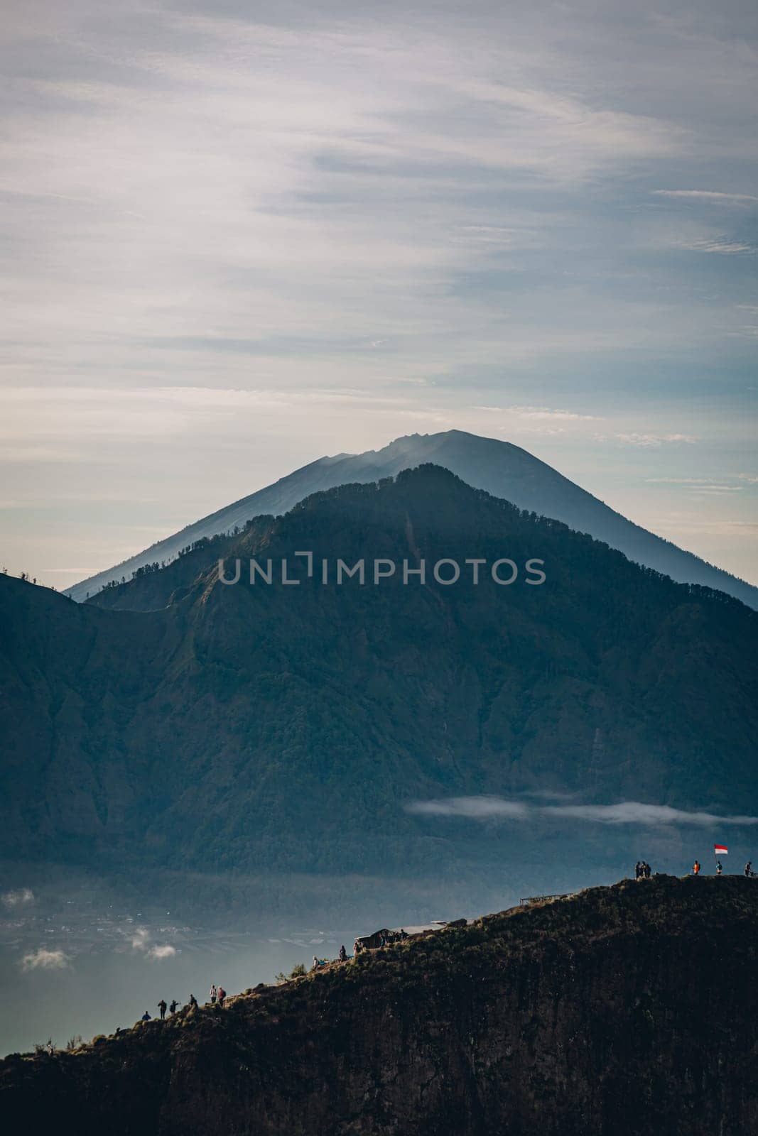 Mountain Batur landscape view in foggy morning. Volcano Batur silhouette with misty and cloudy sky