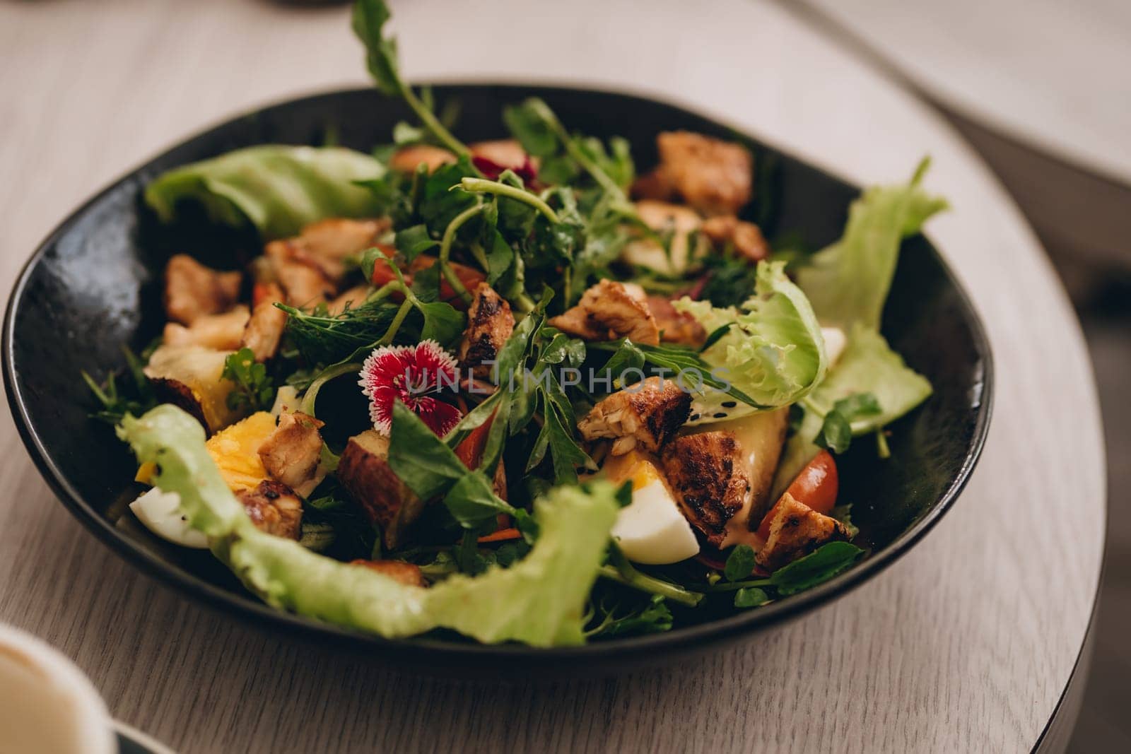 Close up shot of summer salad bowl with wooden table background.