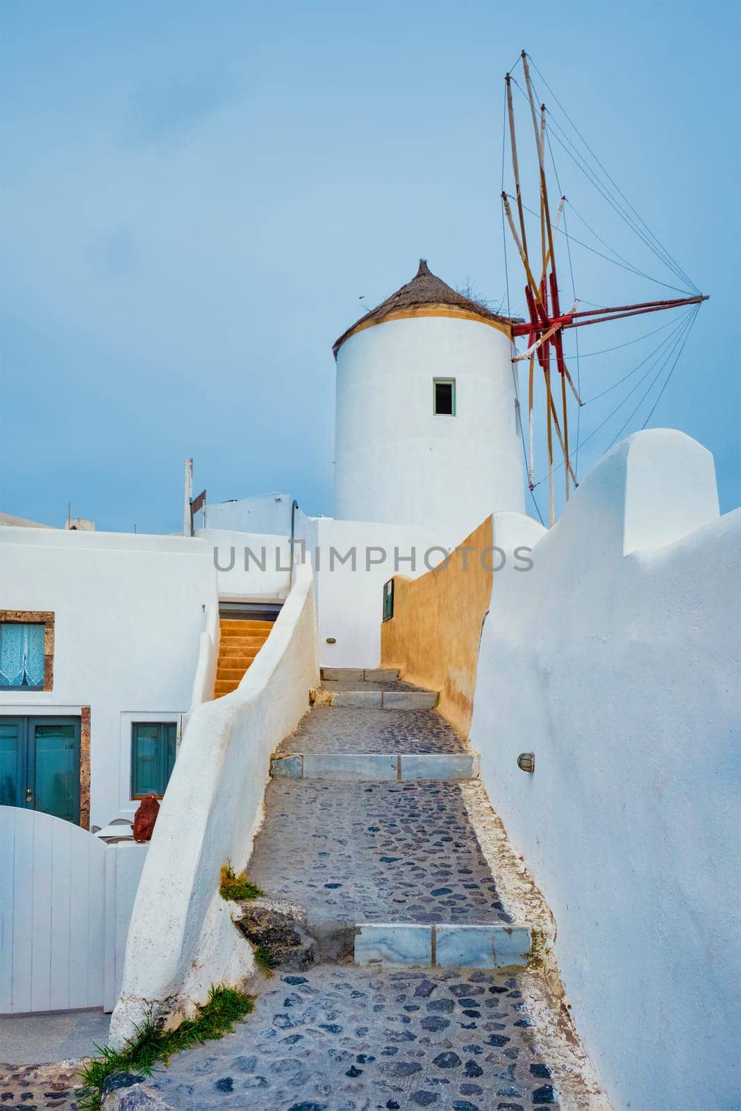 Old greek windmill on Santorini island in Oia town with stairs in street. Santorini, Greece by dimol