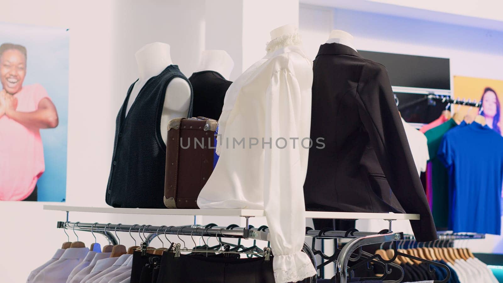 Shopping mall boutique filled with fashion tailoring, multiple racks with fashionable formal wear. Empty clothing showroom with trendy shirts on hangers, small business concept.