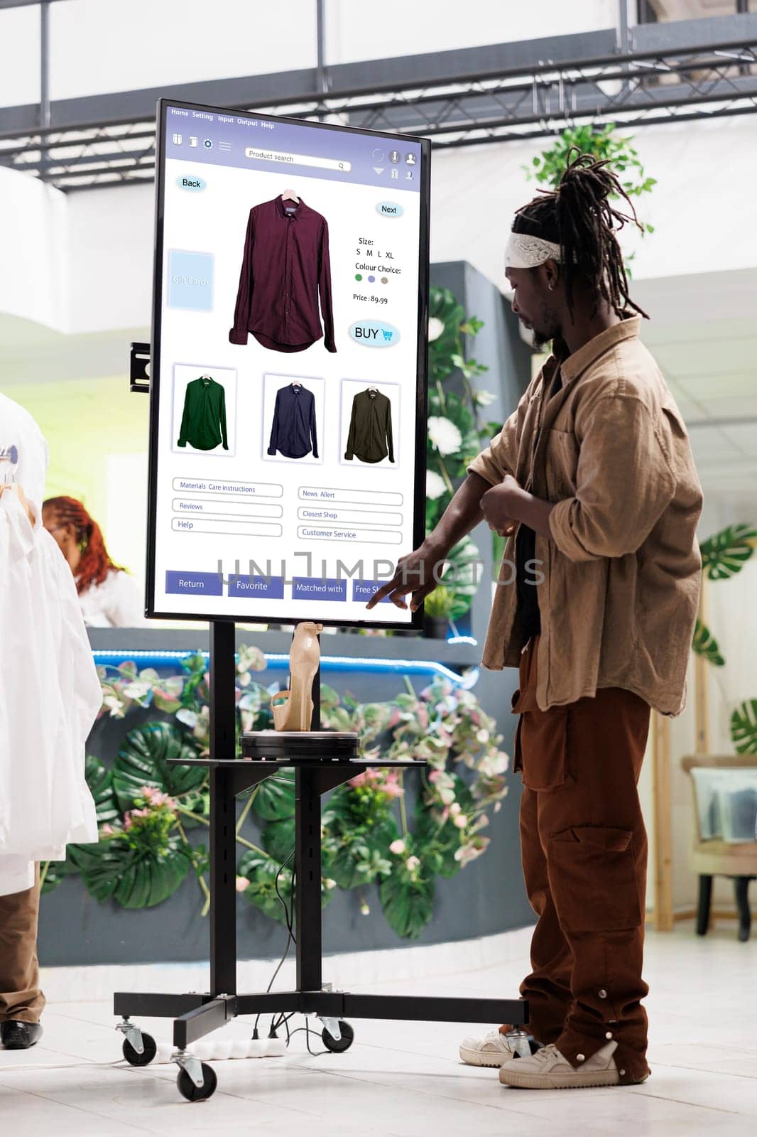 Shopper looks for clothes on monitor by DCStudio
