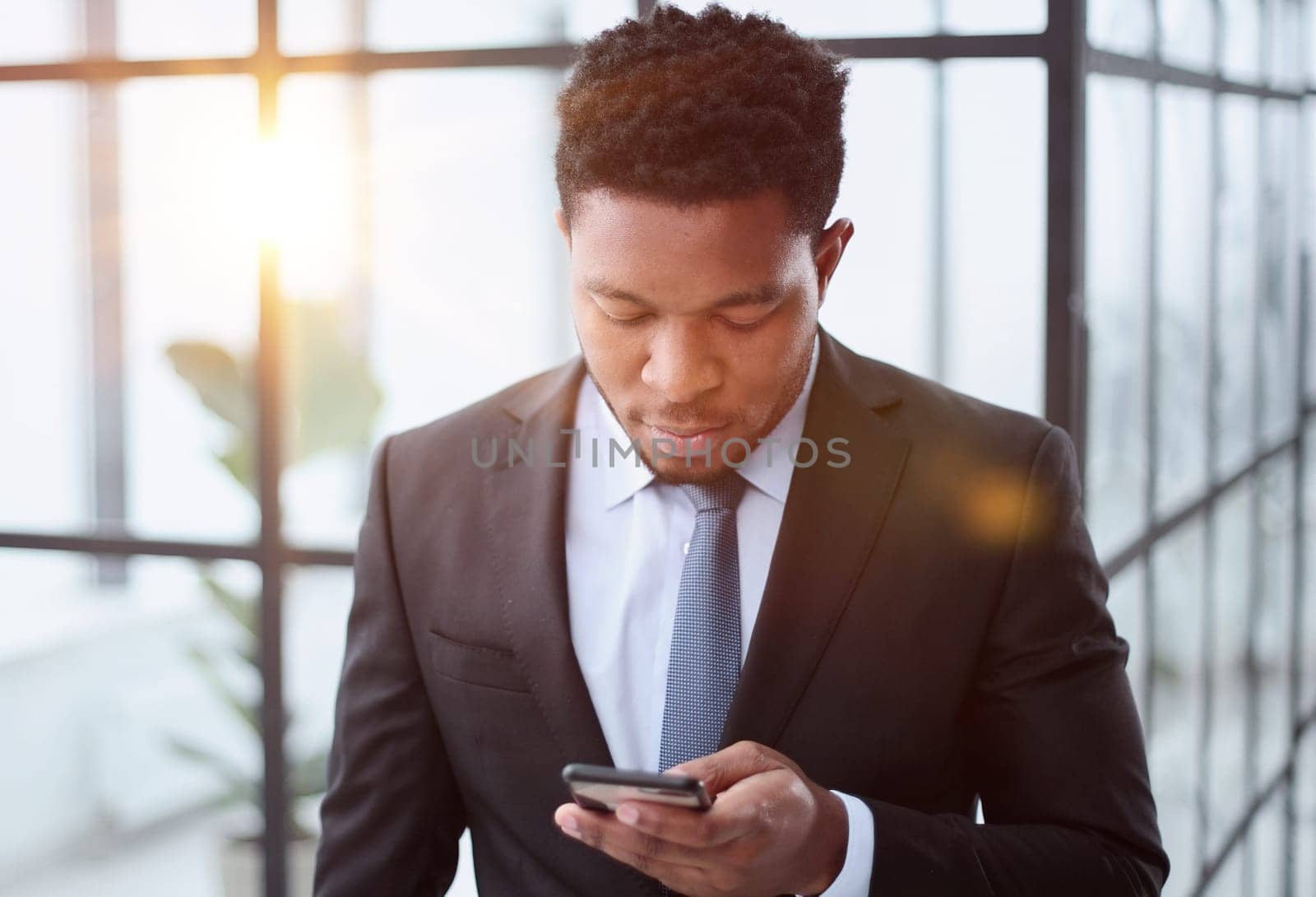 attractive african american young man uses phone