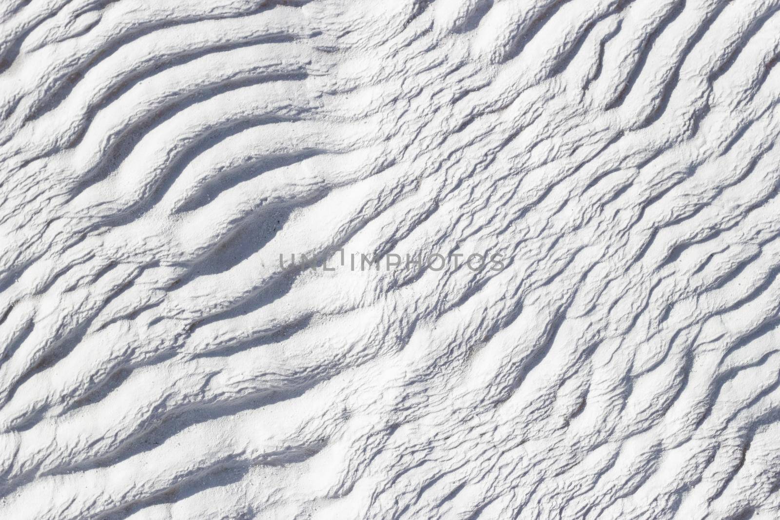 White abstract diagonal texture of Pamukkale calcium travertine in Turkey, asymmetric pattern close-up.