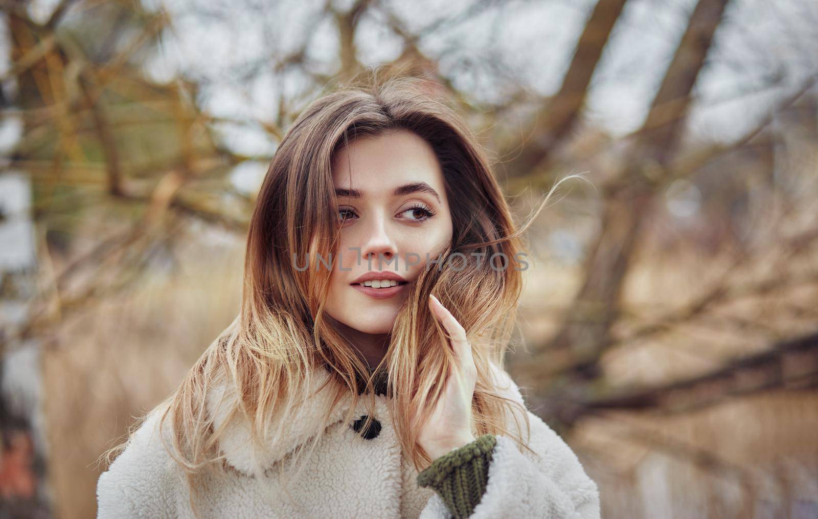 Beautiful woman hair fluttering in the wind. Smiling woman laughing on the street cheerfully. Lovely young lady feeling happy