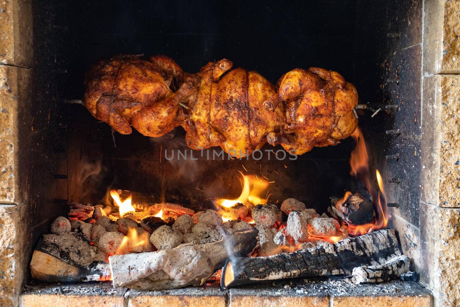 chicken roasting on a spit by artush