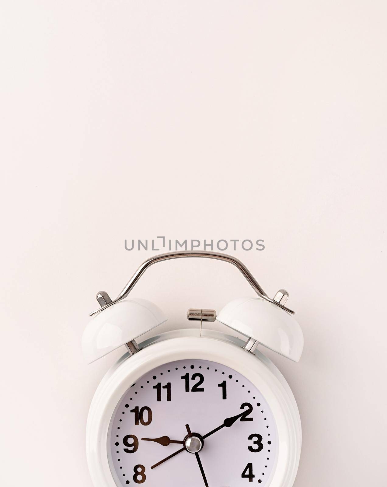 Time management, punctuality, business metaphors. White vintage alarm clock with nine ten , flat lay top view, copy space