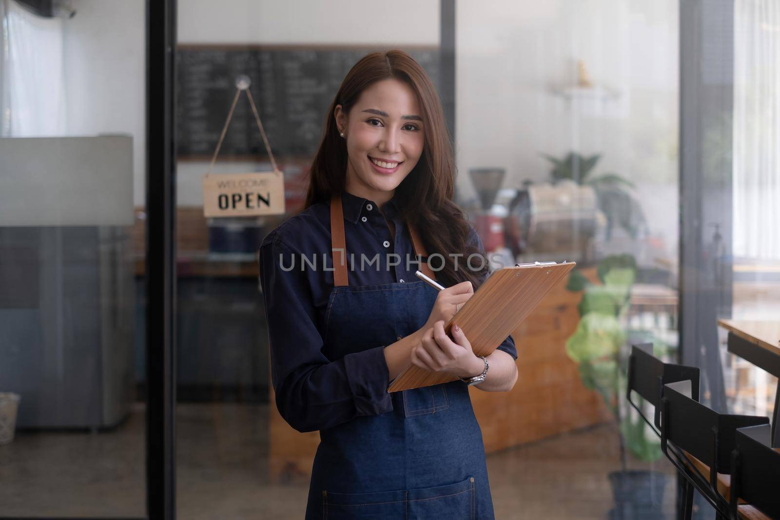 Portrait of a beautiful barista with tablet at her cafe. small business owner concept. by itchaznong