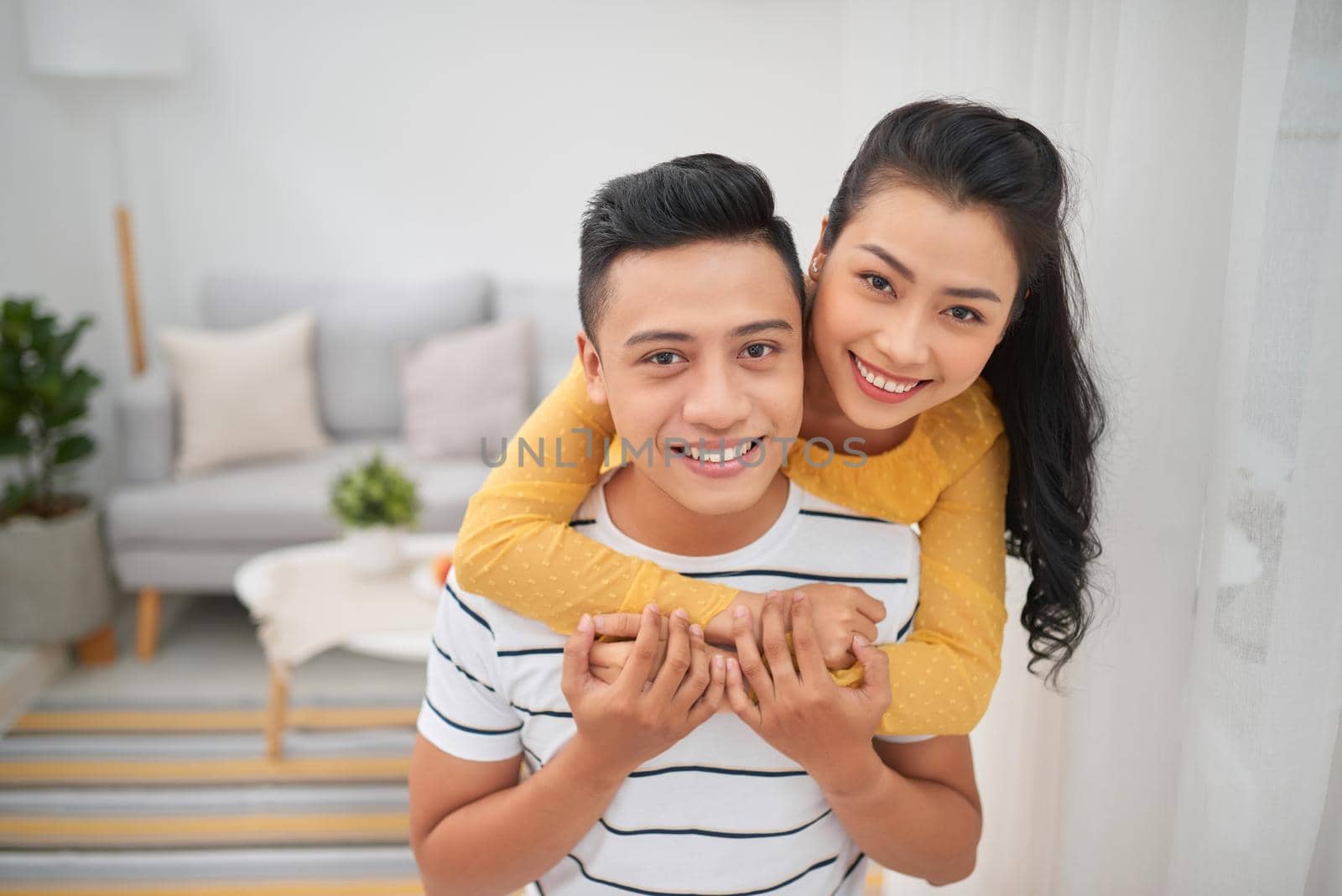 Asian couple piggyback ride indoor