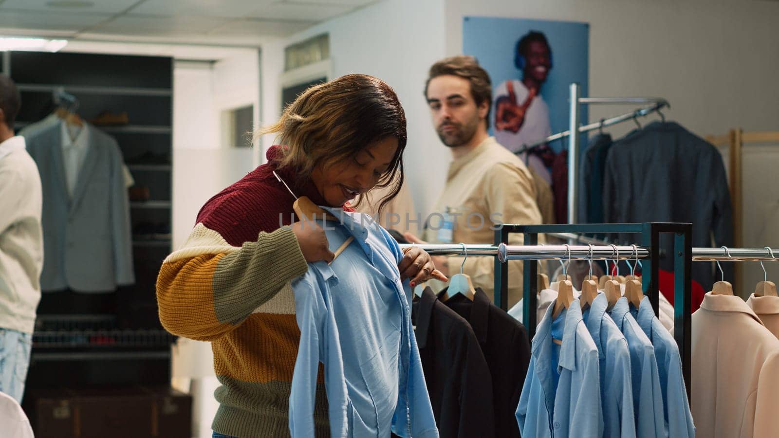 African american client doing shopping for formal wear, examining new retail store merchandise. Young woman checking fashion boutique clothes in clothing store, commercial activity. Tripod shot.