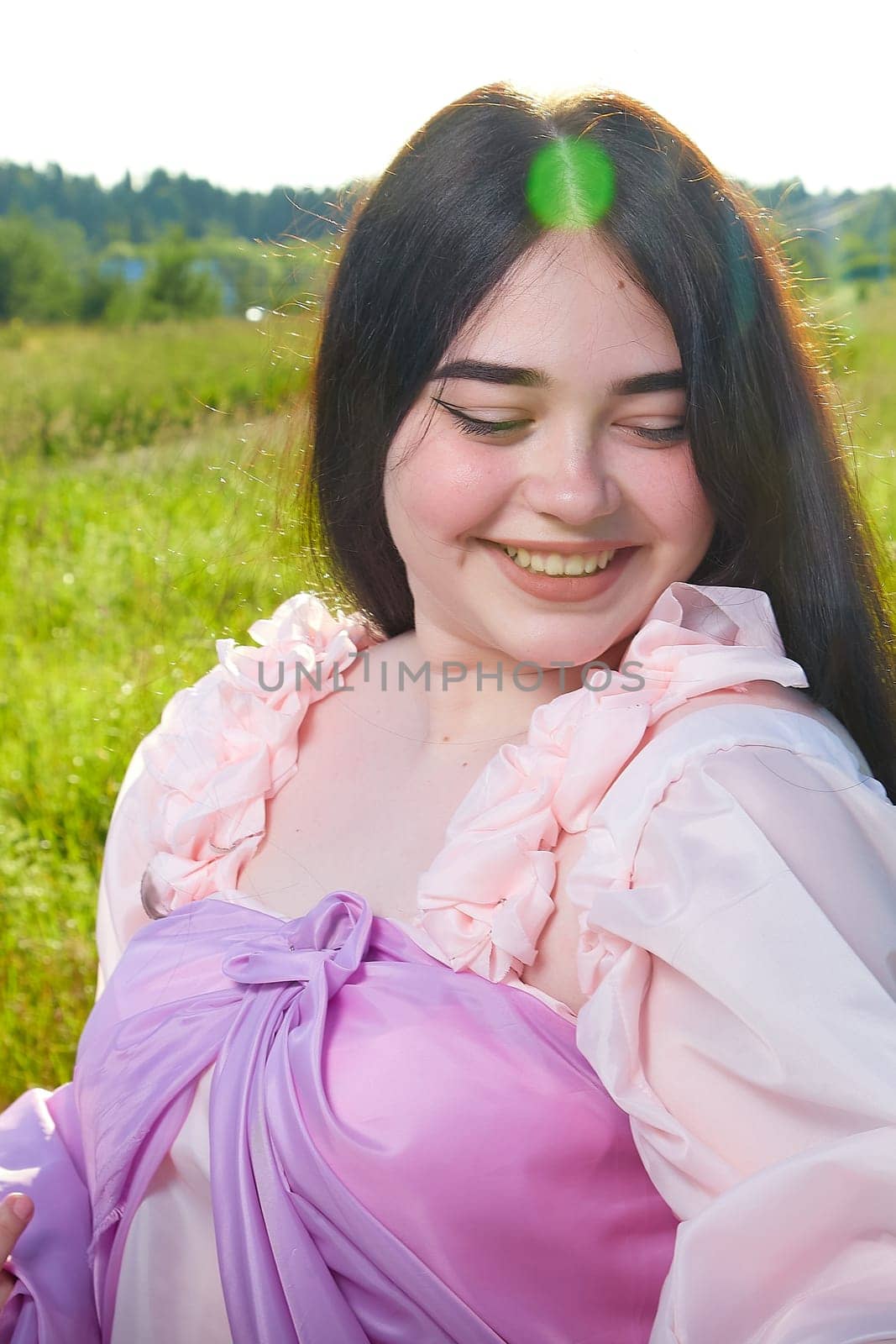 Young plump curvy beautiful teenage girl in a field or meadow on sunny summer day in the evening sunset sun. Plump black-haired and black-eyed oriental model from the east fairy tale