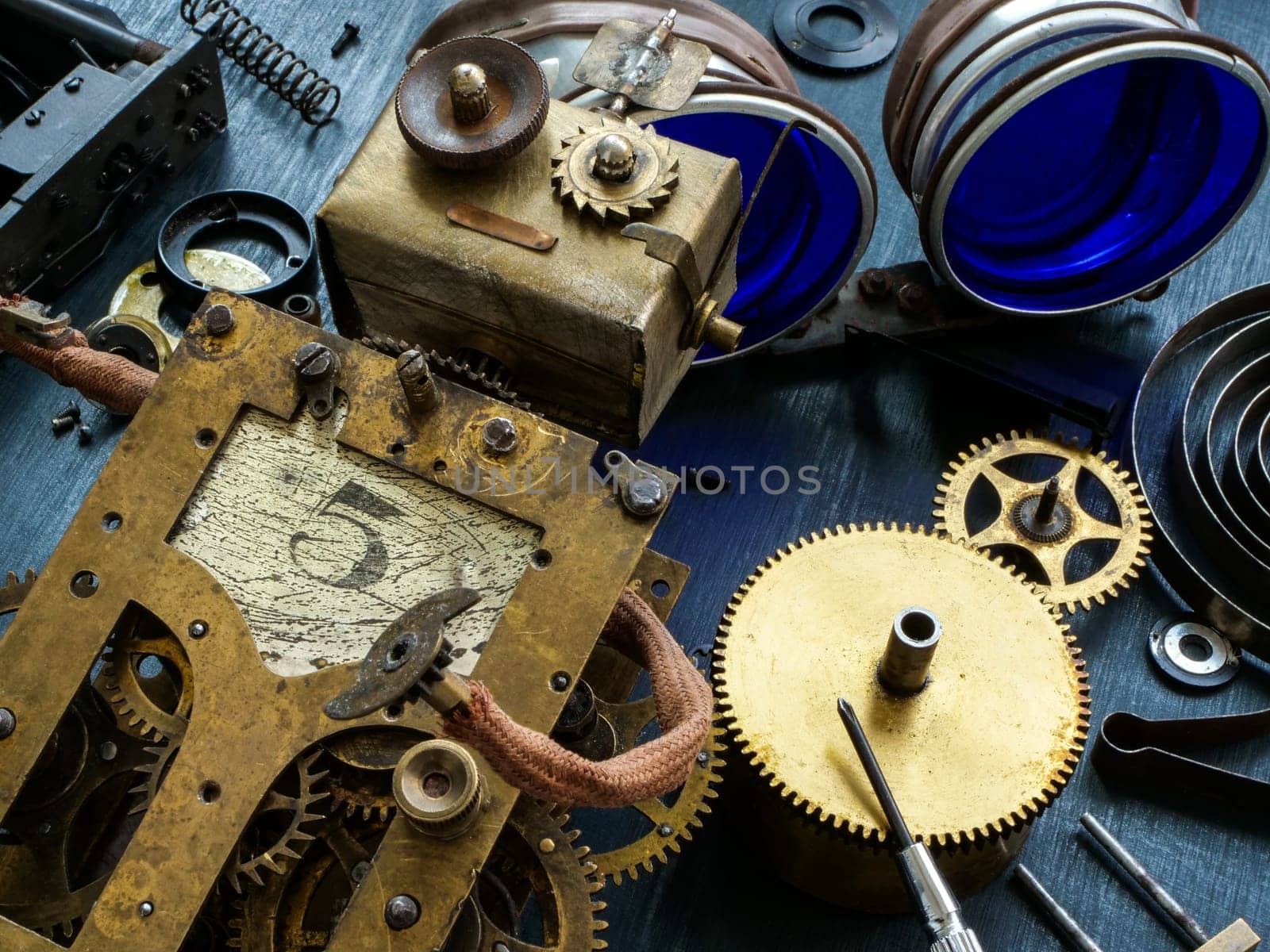 An old, mechanical robot lies on gears and spare parts.