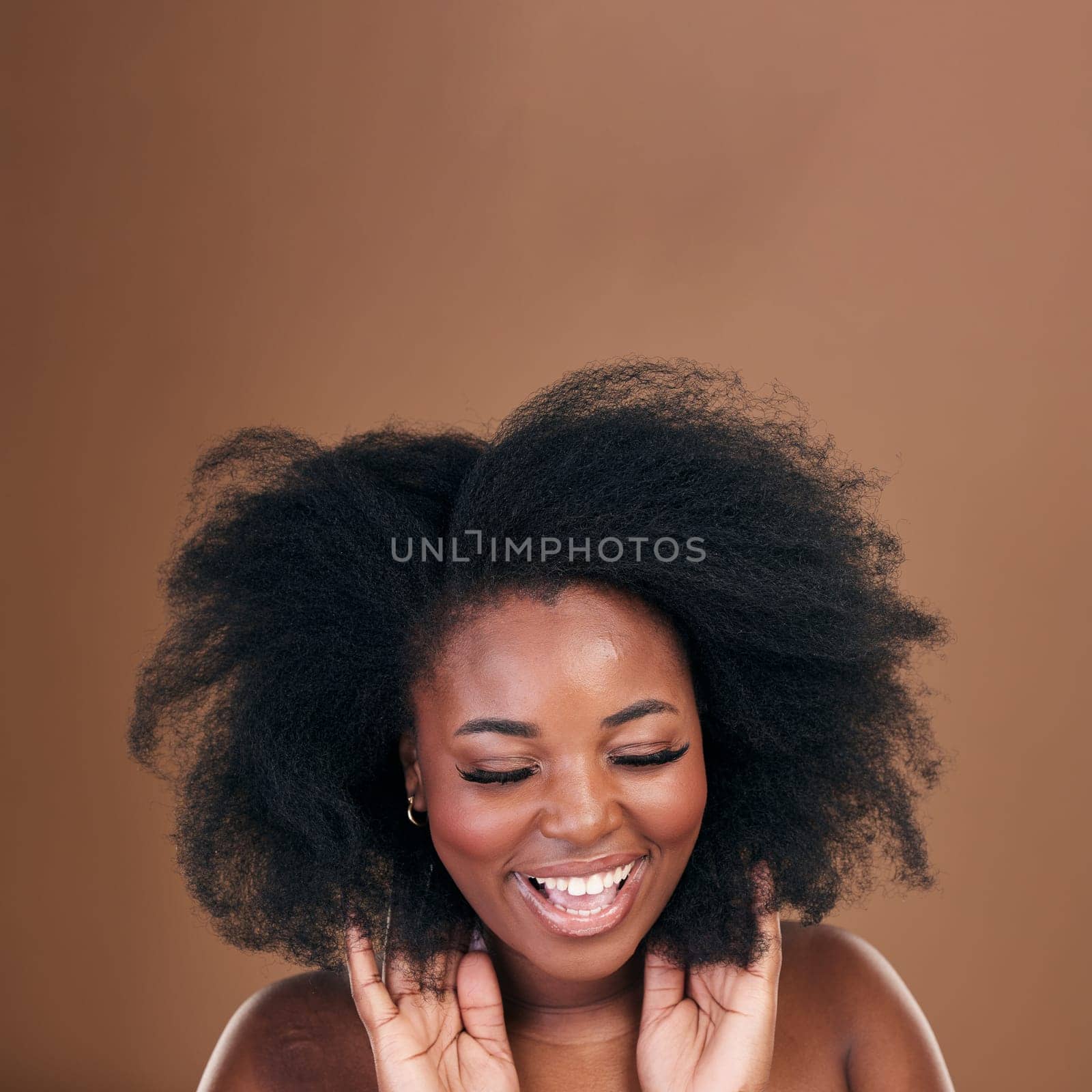 Happy, black woman and hair care for afro, texture and wellness on a brown studio background. Growth, hairstyle and African model with natural beauty, mockup space and salon treatment with cosmetics.