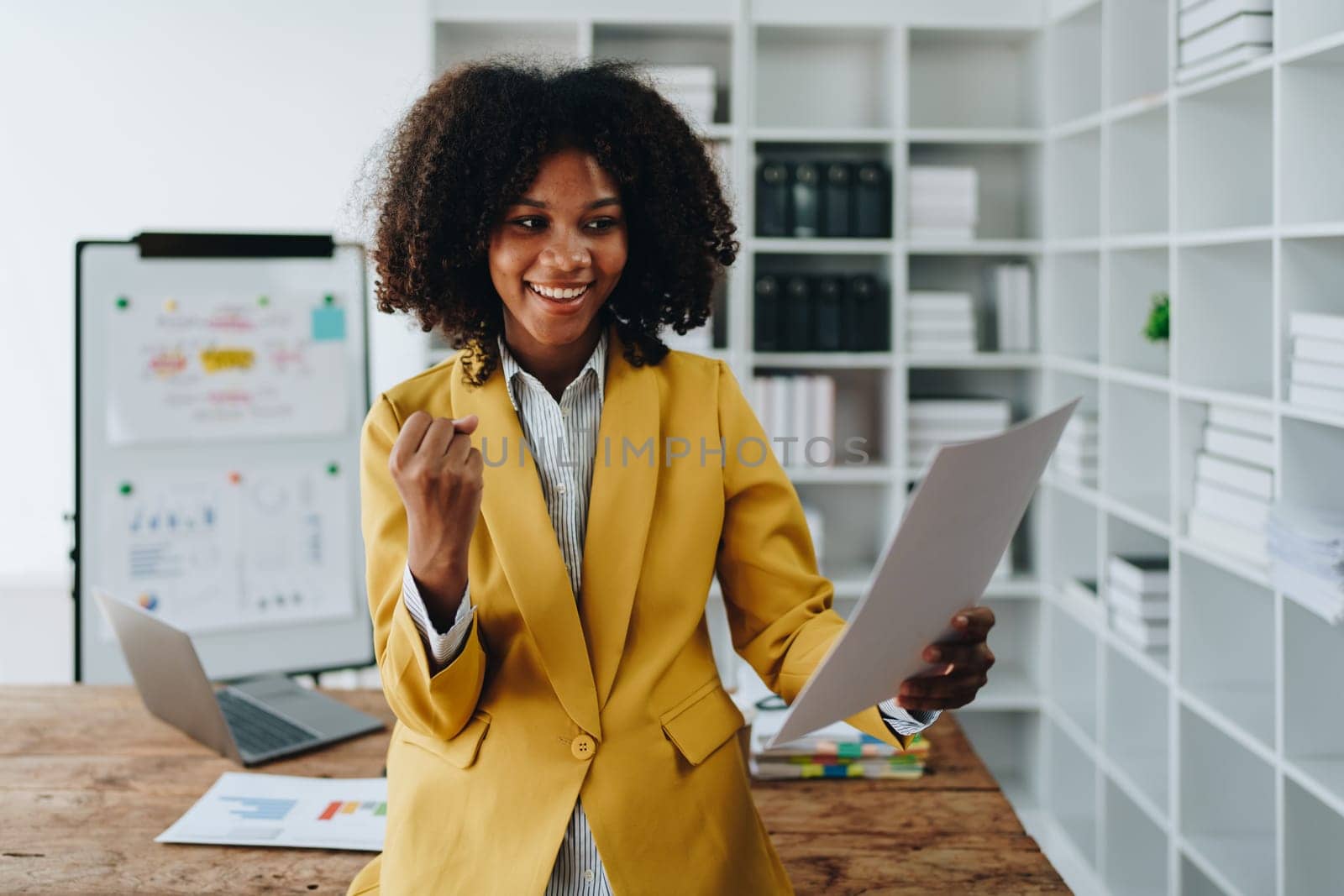 American African business woman using document, computer laptop, calculator, paperwork, documents, in winner and smiling Happy to be successful achievement success. finance and investment concepts.