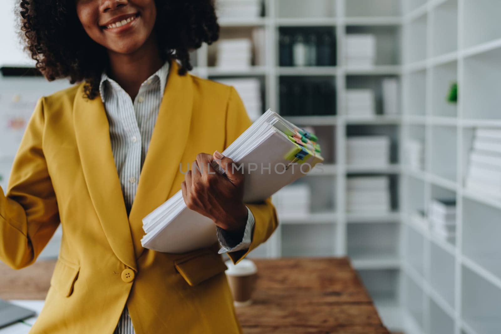 Beautiful young African american businesswoman using laptop computer and paperworks with planning working on financial document, tax, exchange, accounting and Financial advisor by Manastrong