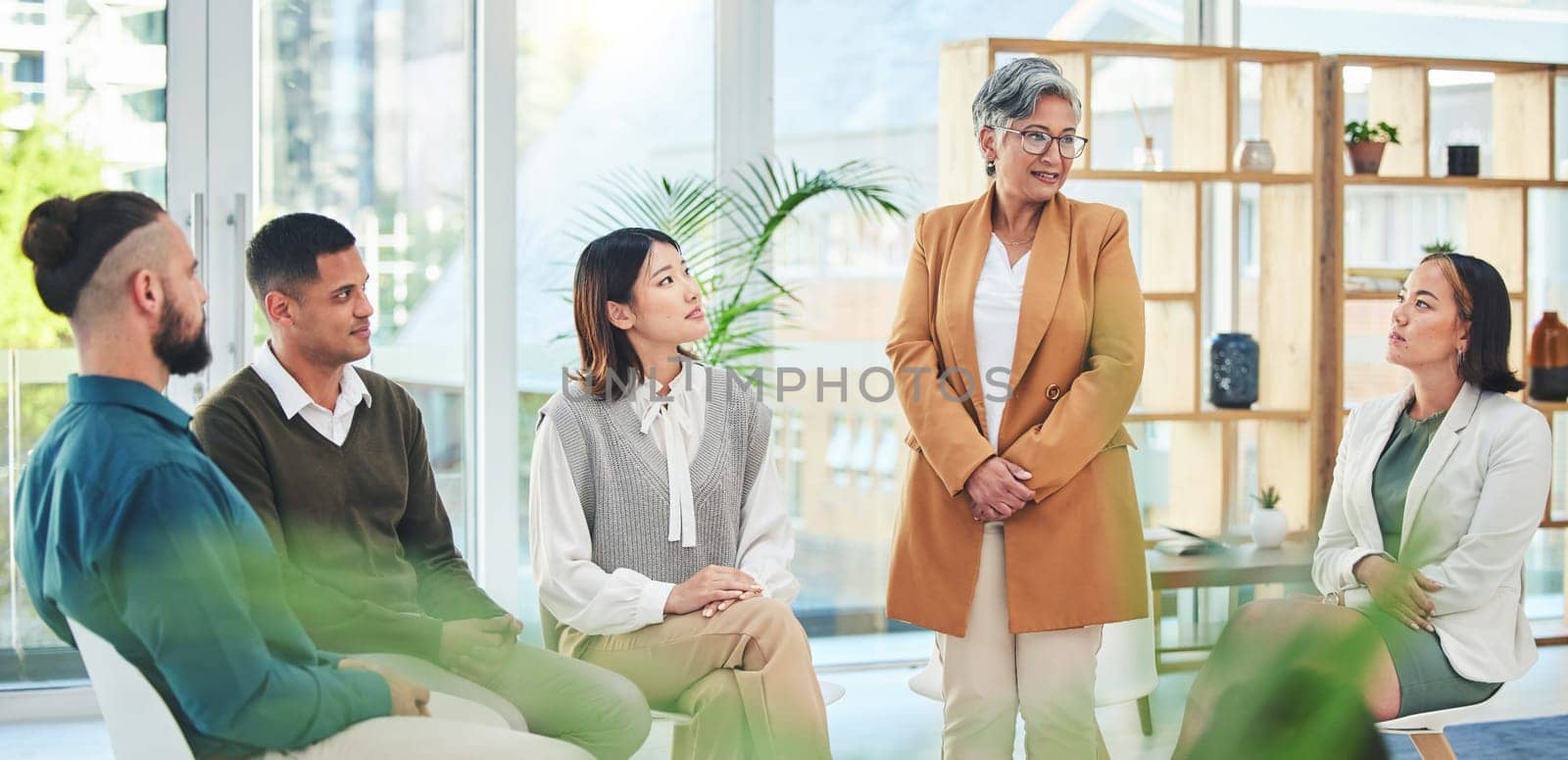 Support, group therapy and senior woman talking in meeting, conversation and wellness. Counseling, psychology and people, therapist and community help in rehabilitation, mental health and healing by YuriArcurs