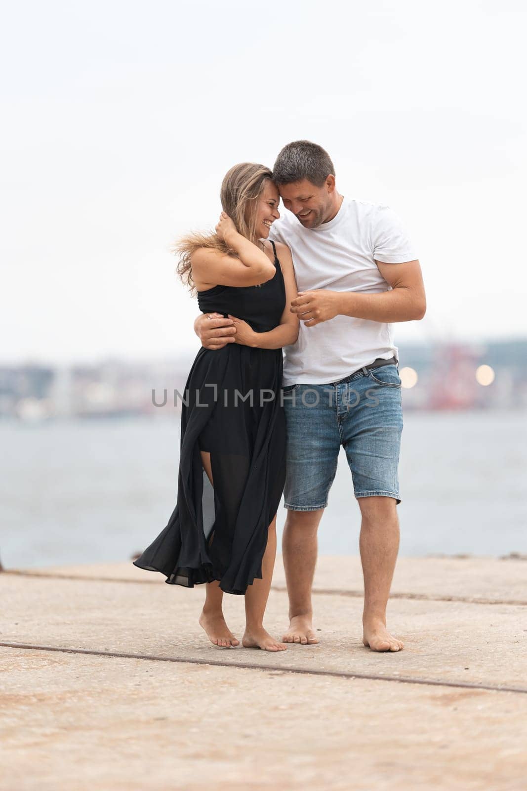 Cute romantic married couple on the pier. Vertical shot