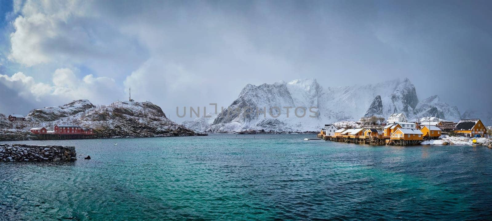 Panorama of yellow rorbu houses of Sakrisoy fishing village with snow in winter. Lofoten islands, Norway