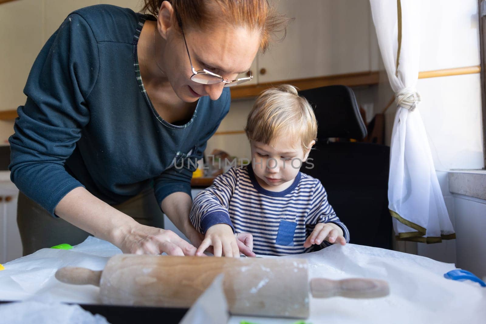 Mom and son making cookies on the kitchen. Mid shot