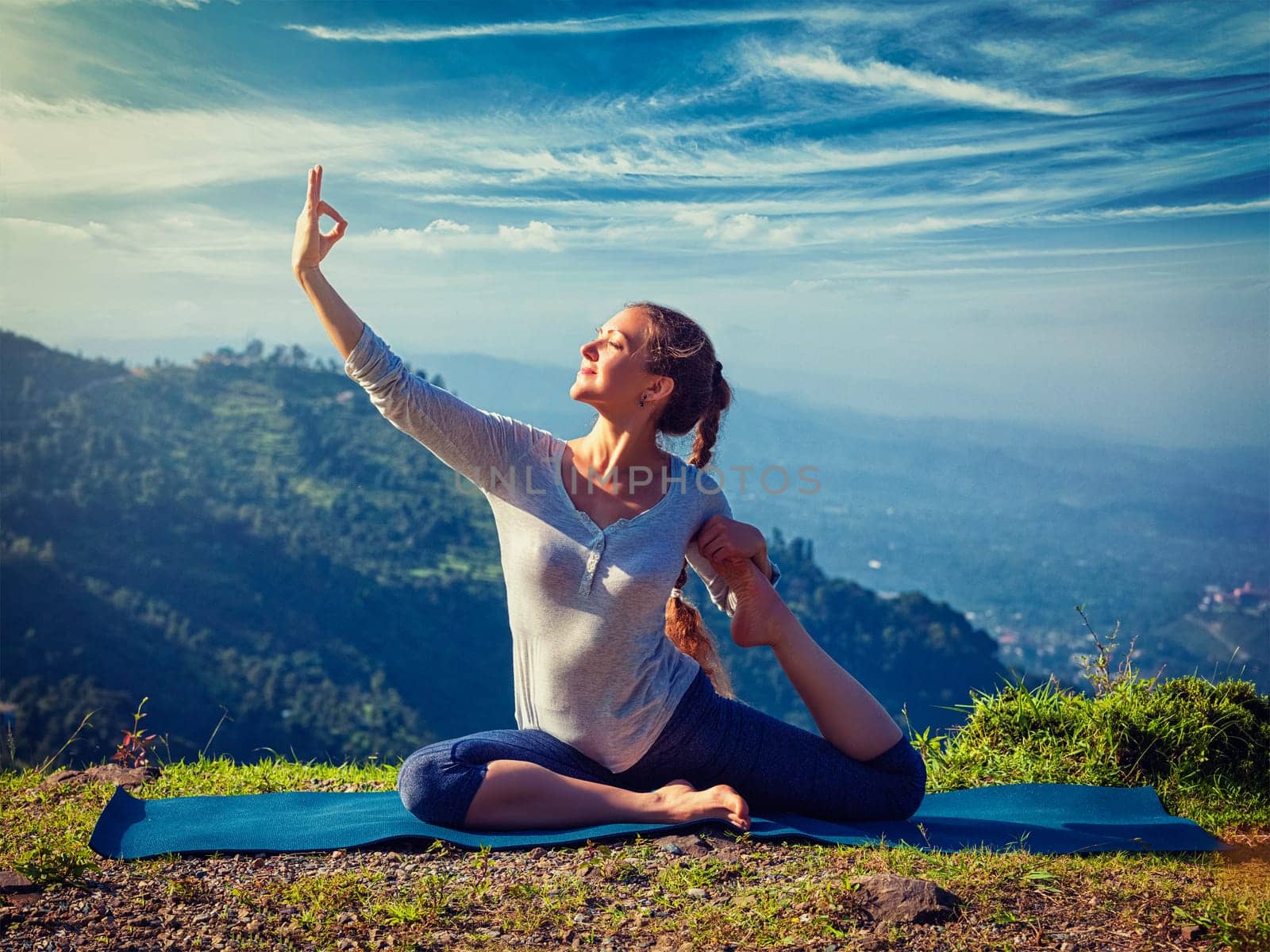 Sorty fit woman doing yoga asana outdoors in mountains by dimol