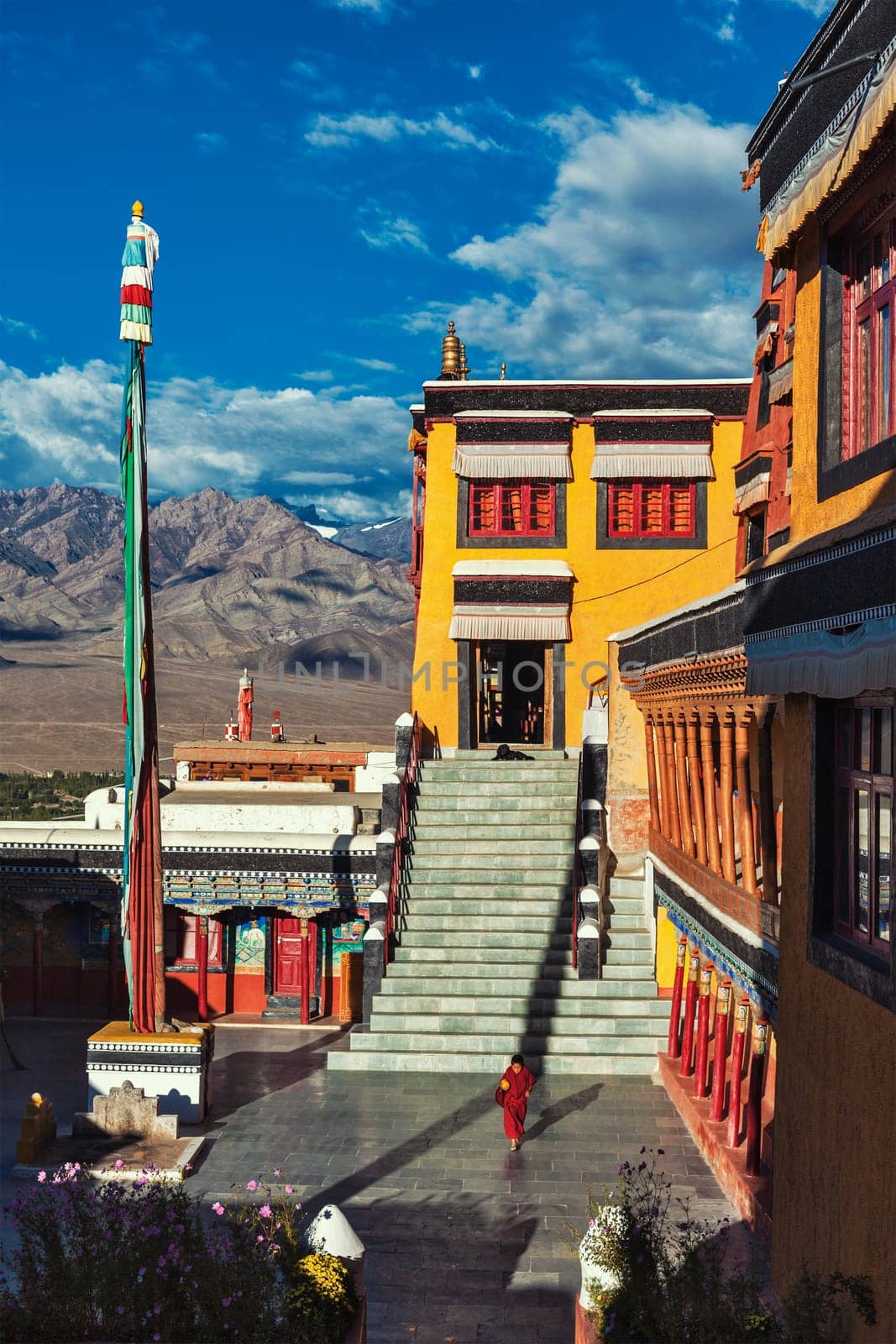 THIKSEY, INDIA - SEPTEMBER 13, 2012: Young Buddhist monk running in the courtyard of Thiksey gompa Buddhist monastery in Ladakh, India