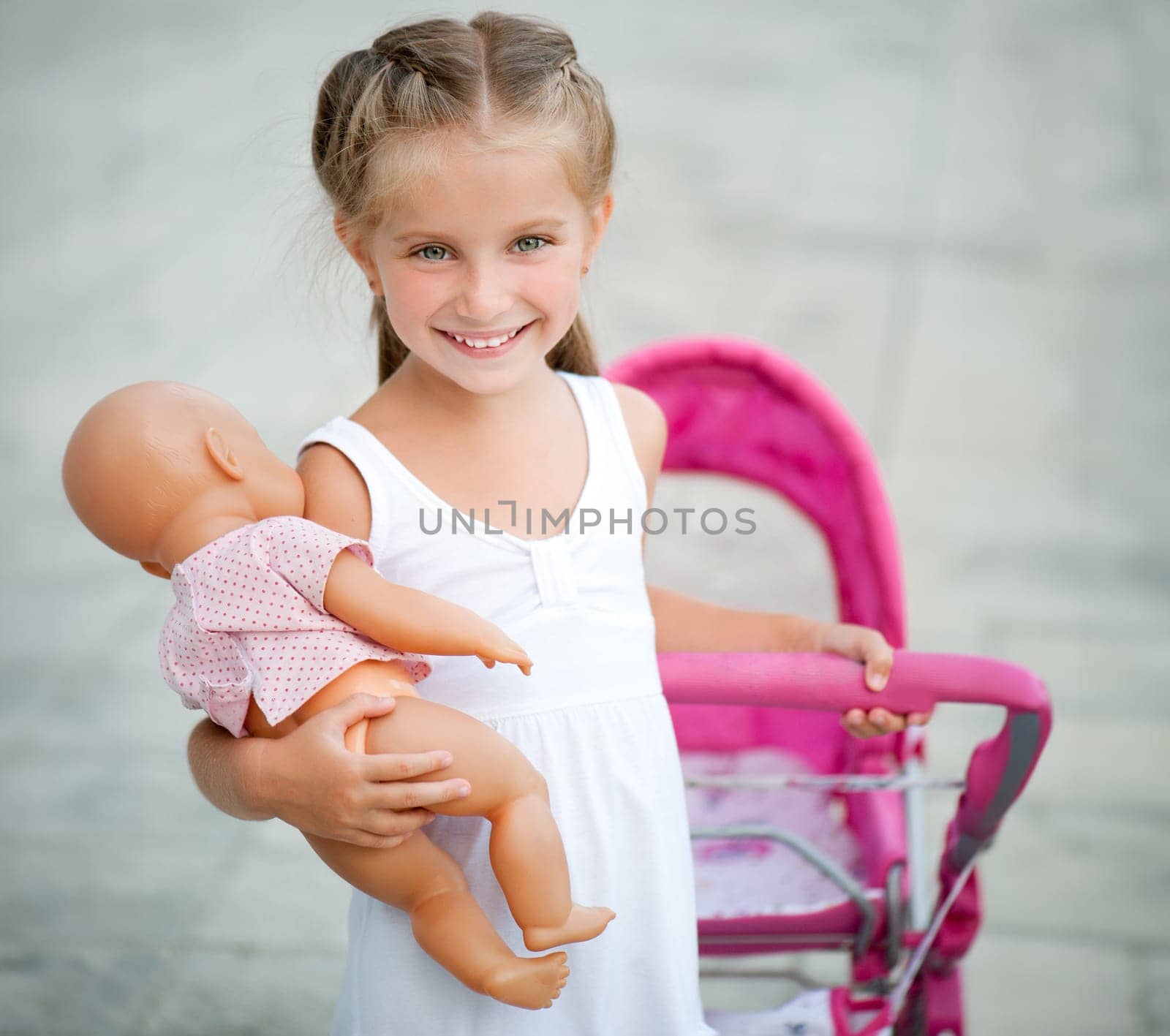 Cute little girl with her toy carriage