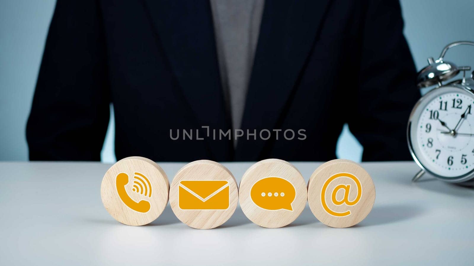 Website page, contact us or email marketing concept, customer support hotline, contact us. Businessman sitting and working on computer. Email, phone, address, chat message icon. by Unimages2527