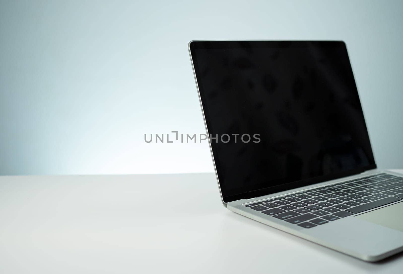 The computer image has a blank black screen. placed on a white table by Unimages2527