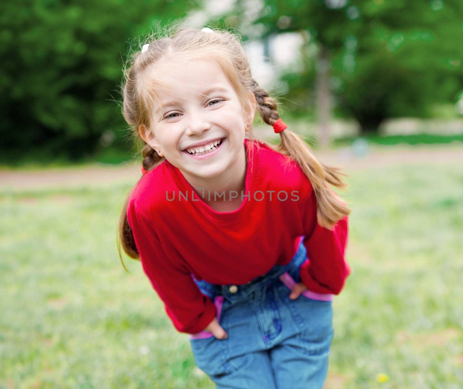 Cute little girl on the meadow in summer day