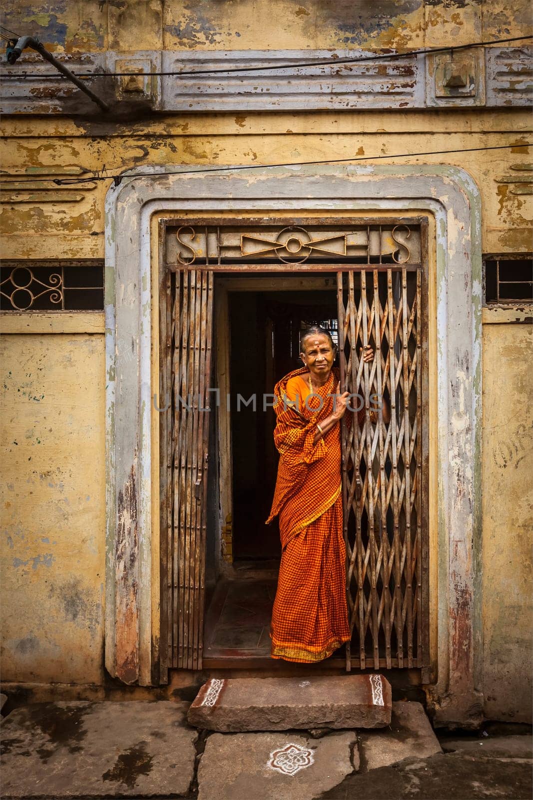 TIRUCHIRAPPALLI, INDIA - FEBRUARY 15, 2013: Unidentified India woman standing in the doorway of her house