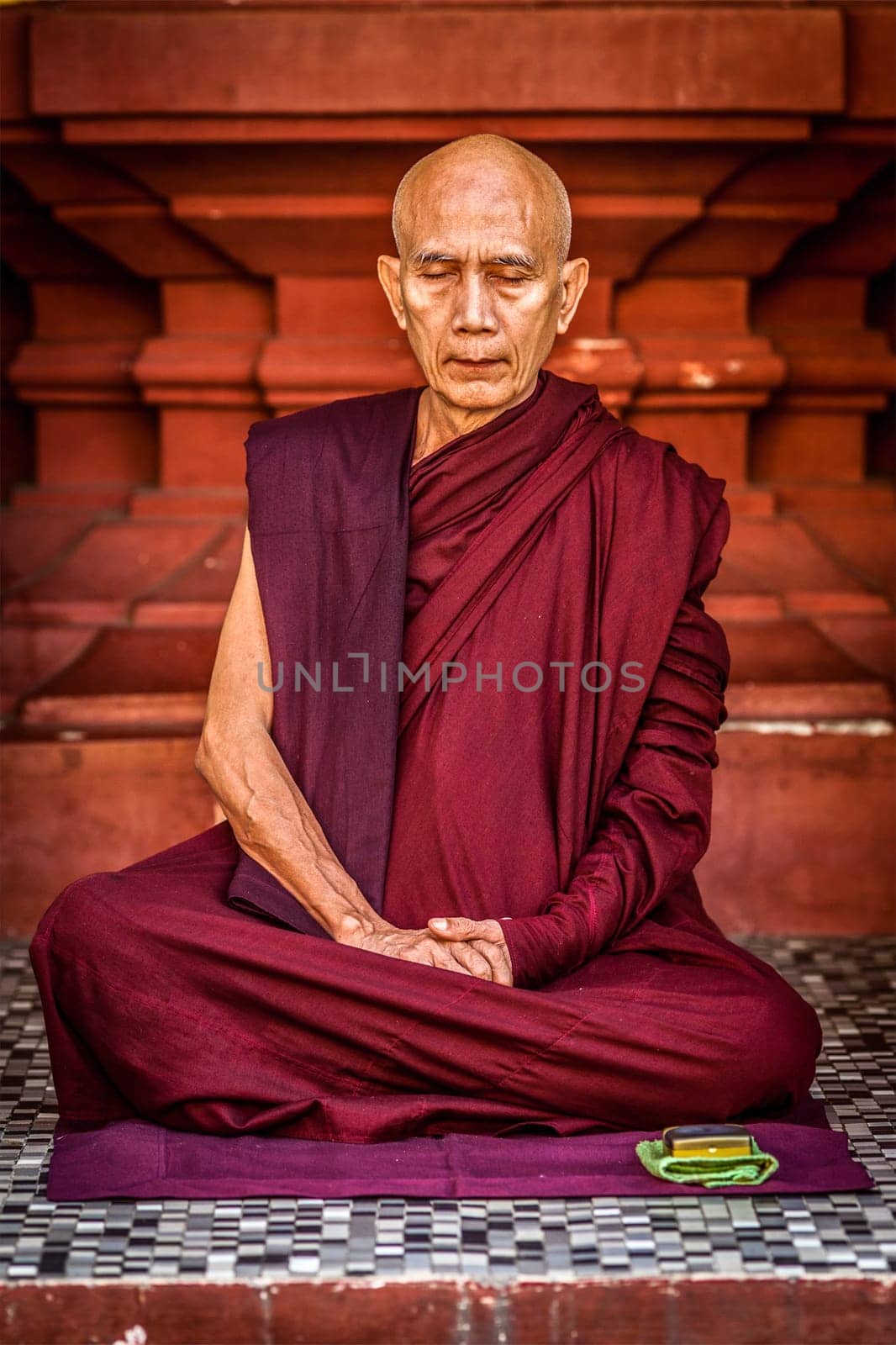YANGON, MYANMAR - JANUARY 3, 2014: Ascetic Buddhist monk meditating in Shwedagon Paya pagoda