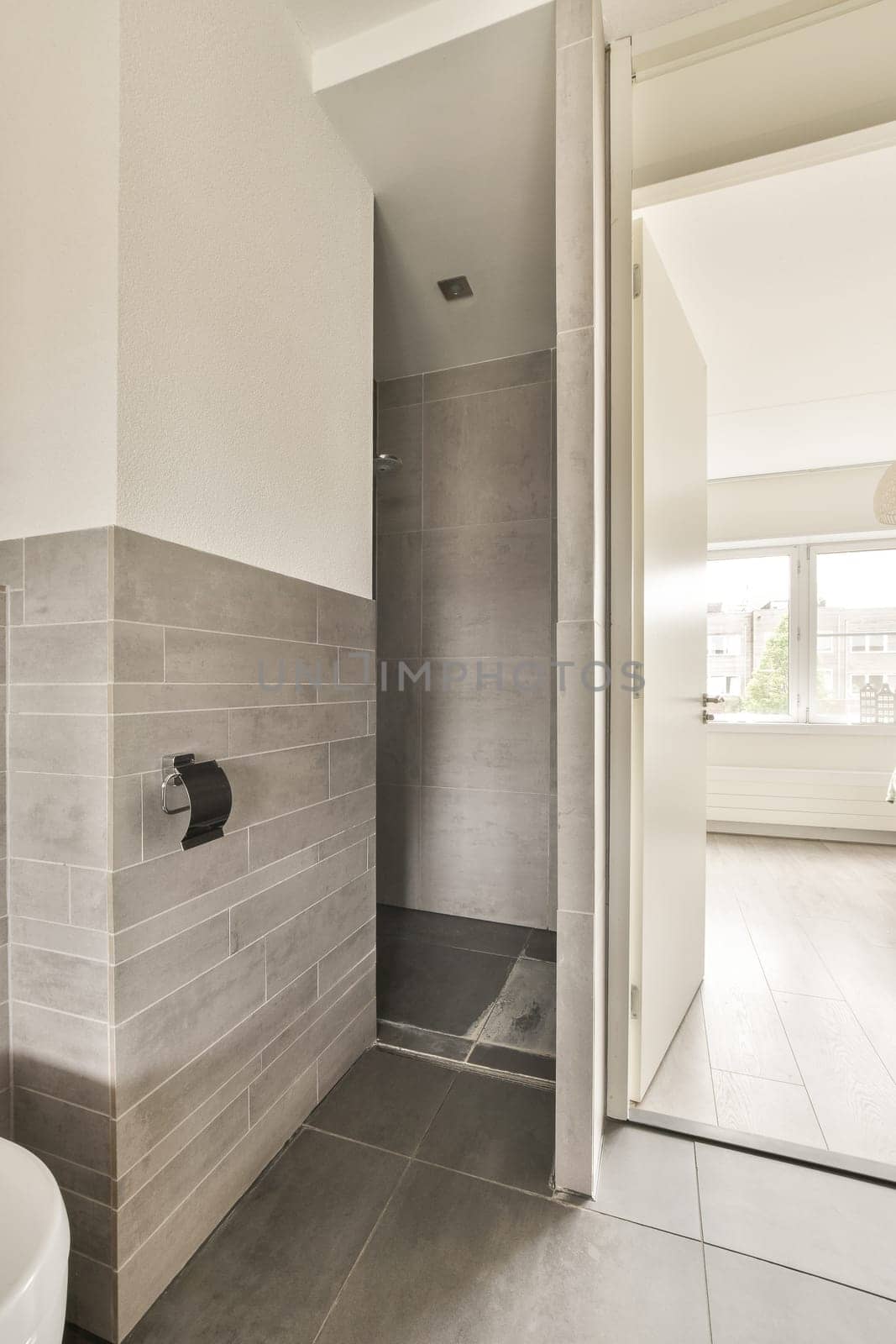 a bathroom with a toilet and shower stall on the floor in front of an open door that leads to a walk - in shower