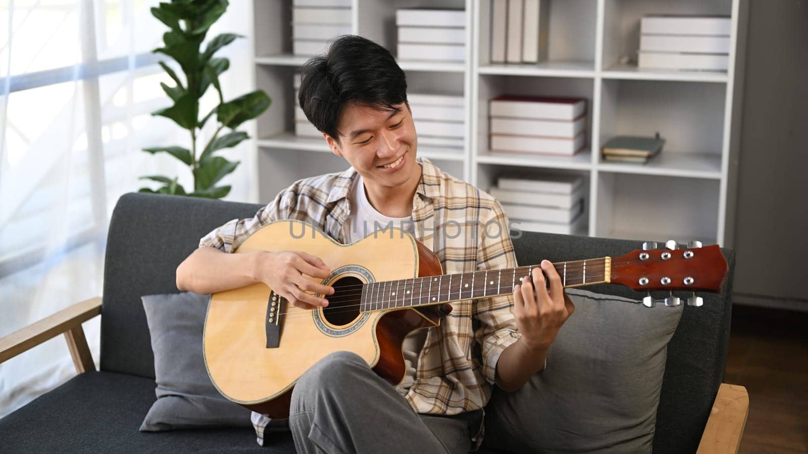 A man playing a guitar at home. Domestic life concept..