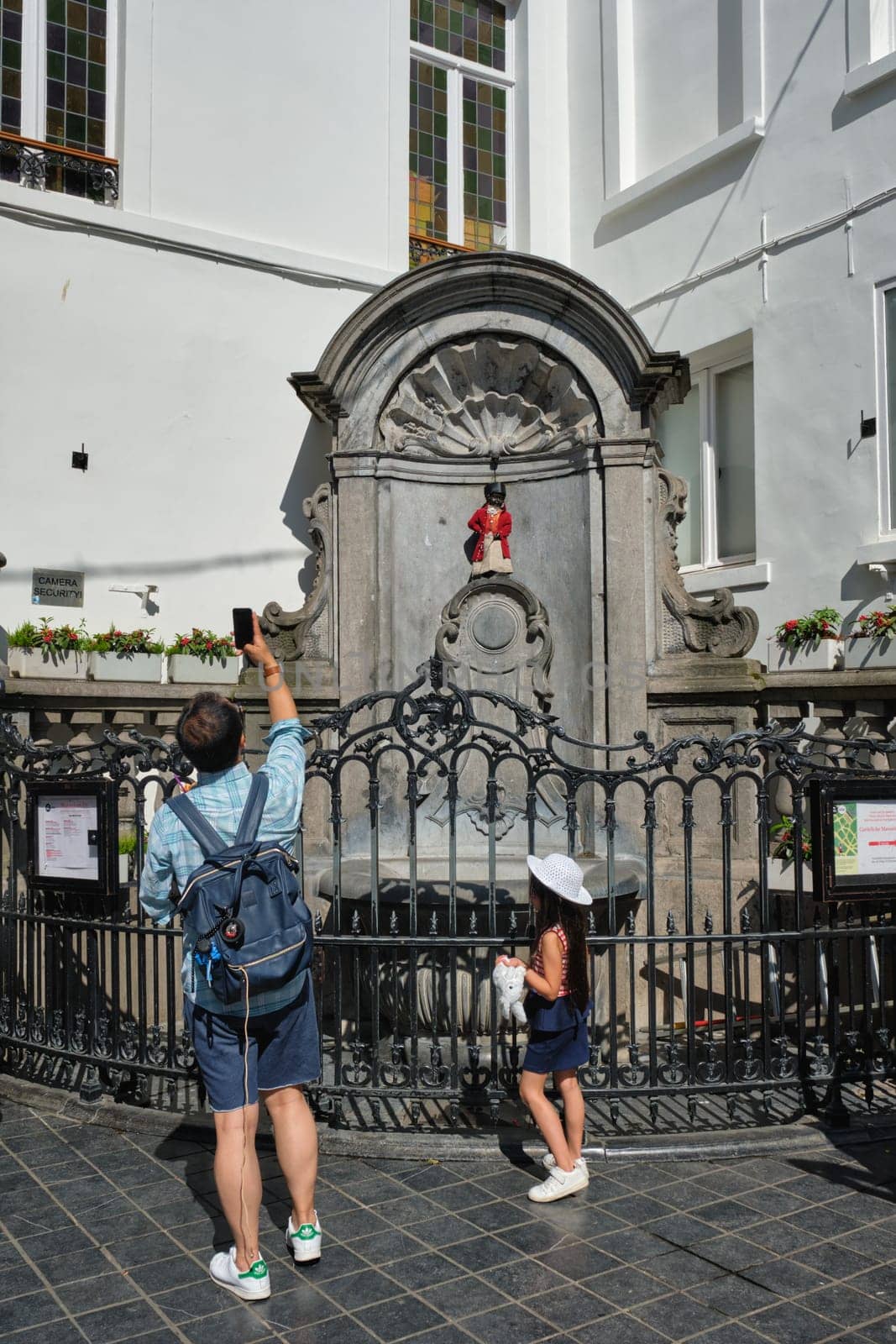 BRUSSELS, BELGIUM - MAY 31, 2018: Tourist taking pictures in front of famous tourist attraction of Brussels - dressed Manneken Pis statue fountain in Brussels. Bruxelles, Belgium