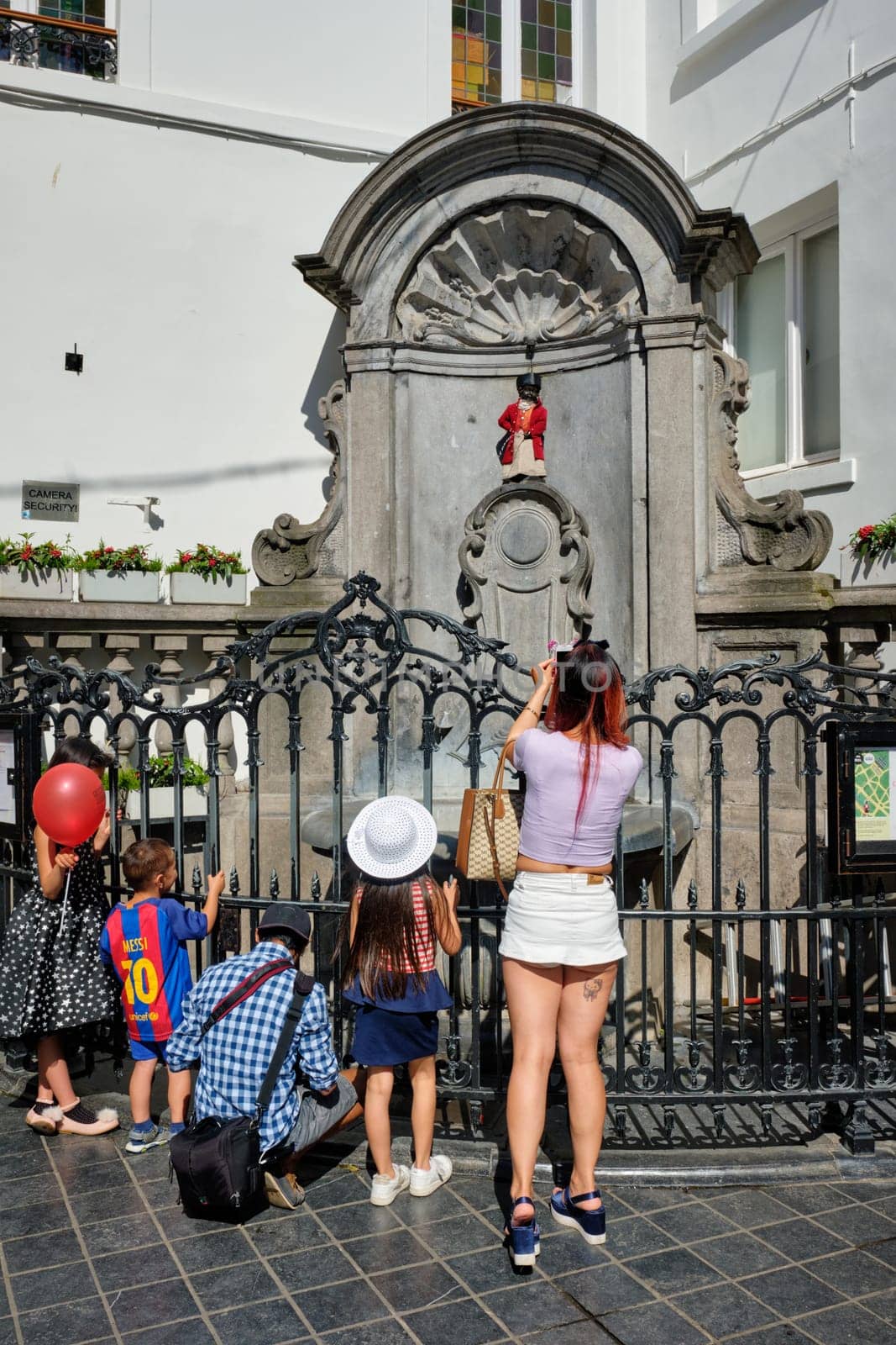 BRUSSELS, BELGIUM - MAY 31, 2018: Tourist taking pictures in front of famous tourist attraction of Brussels - dressed Manneken Pis statue fountain in Brussels. Bruxelles, Belgium