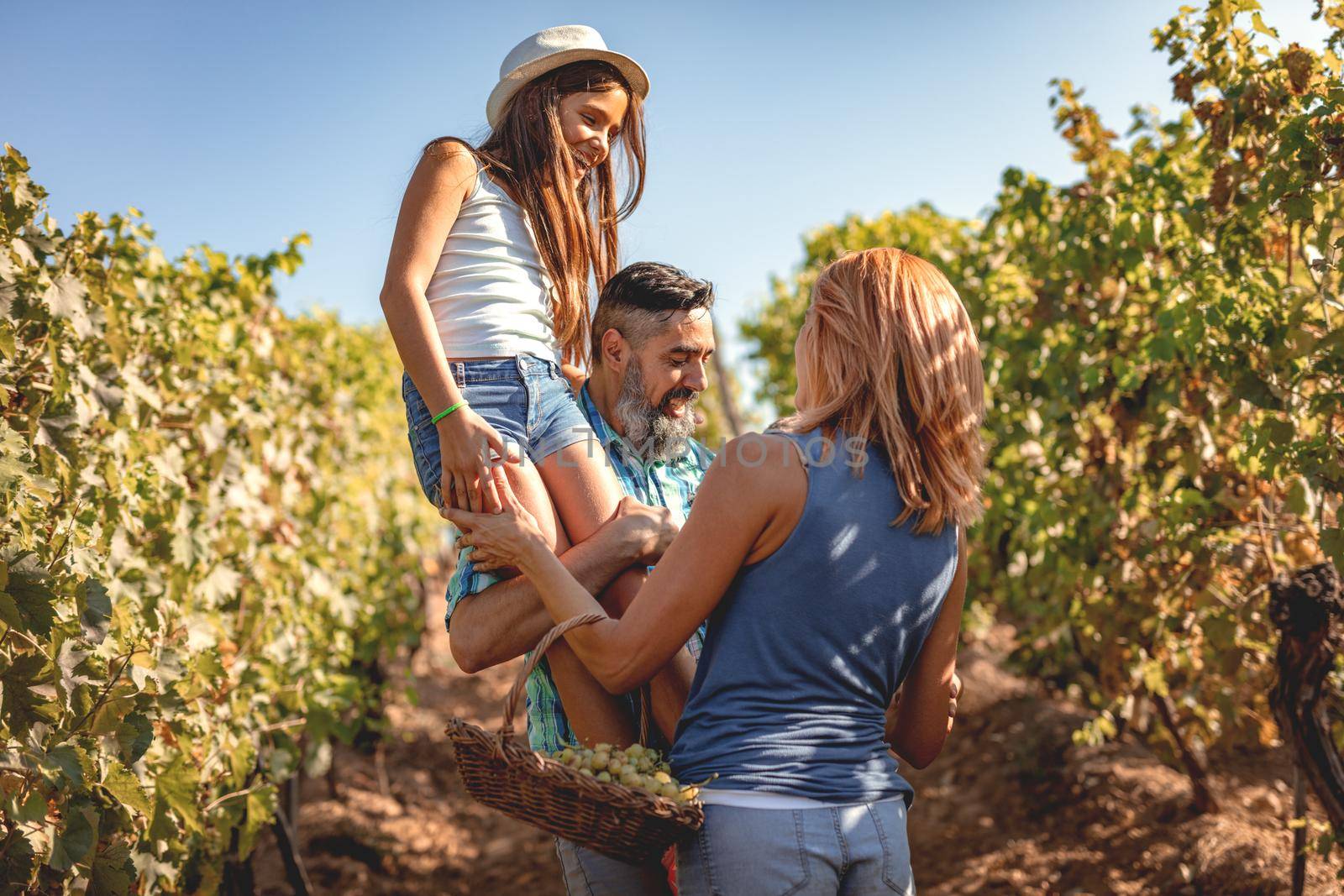Beautiful young smiling family of four having fun at a vineyard.