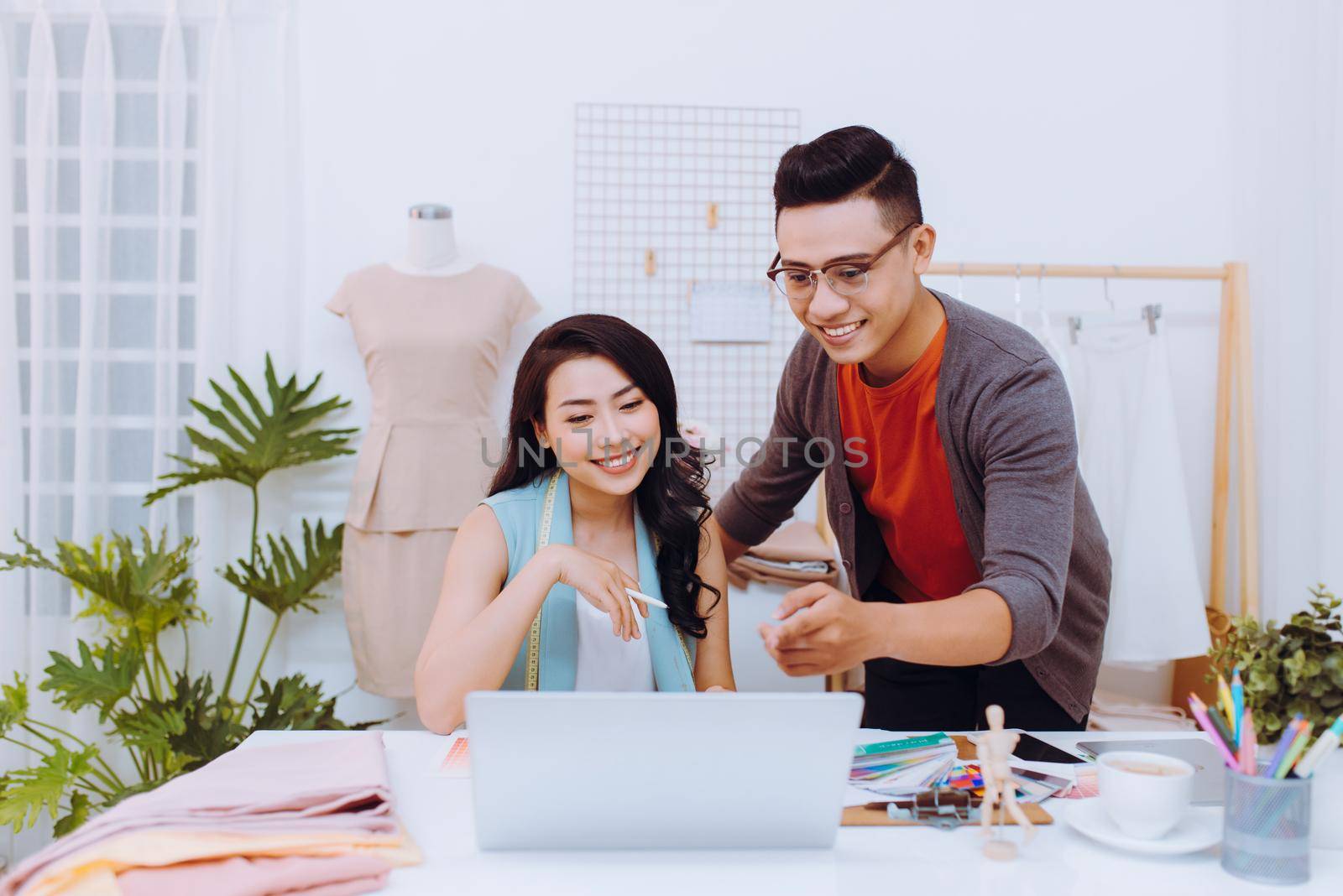 Photo of cheerful woman and man designers working in the studio