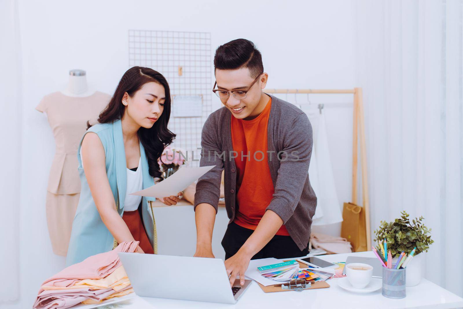 Young woman and man fashion designer using laptop to search for new ideasYoung woman and man fashion designer using laptop to search for new ideas by makidotvn