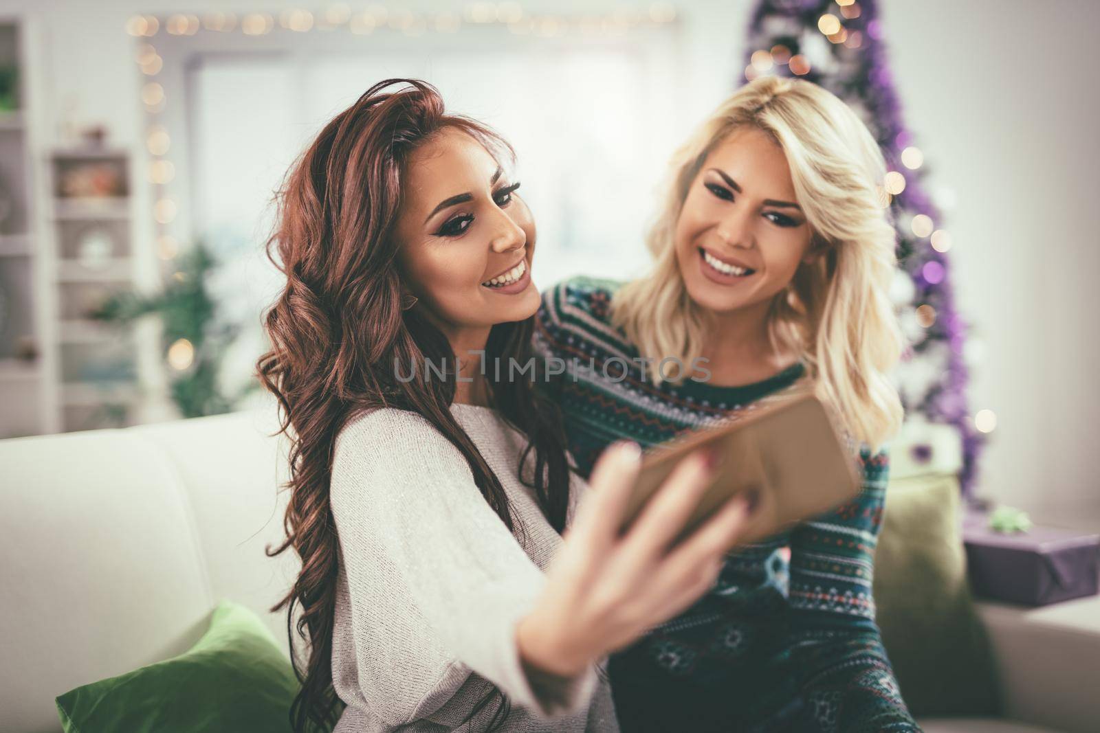 Three cheerful best friends having nice time in an apartment and taking a selfie. Selective focus. 