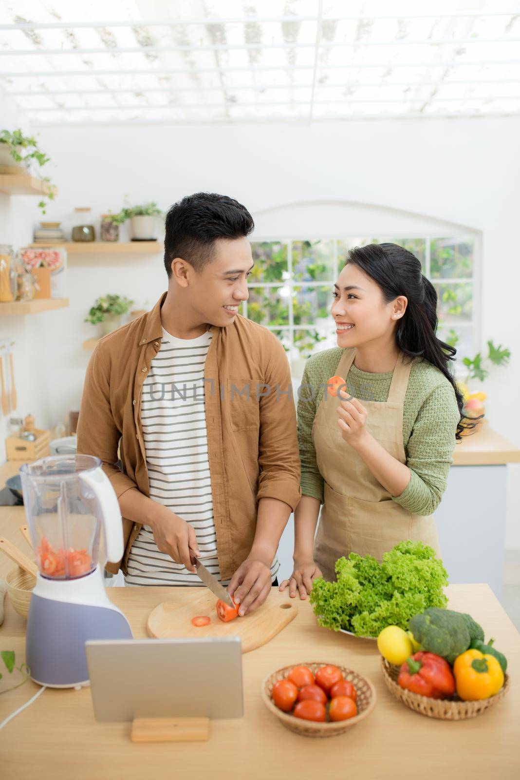 Young Asian couple. Standing cooking in the kitchen. 